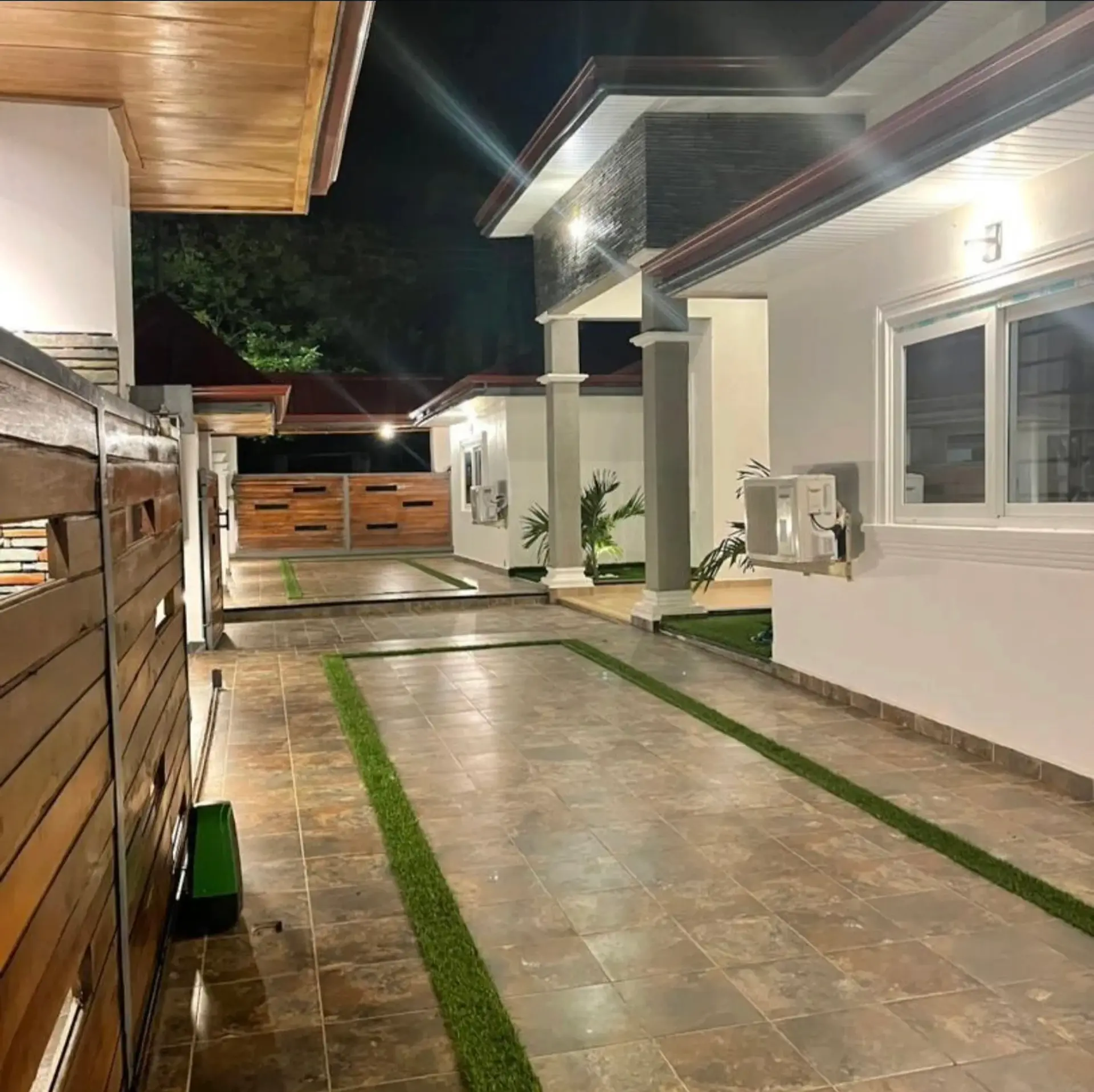 The gated villa compound with perimeter lighting at twilight