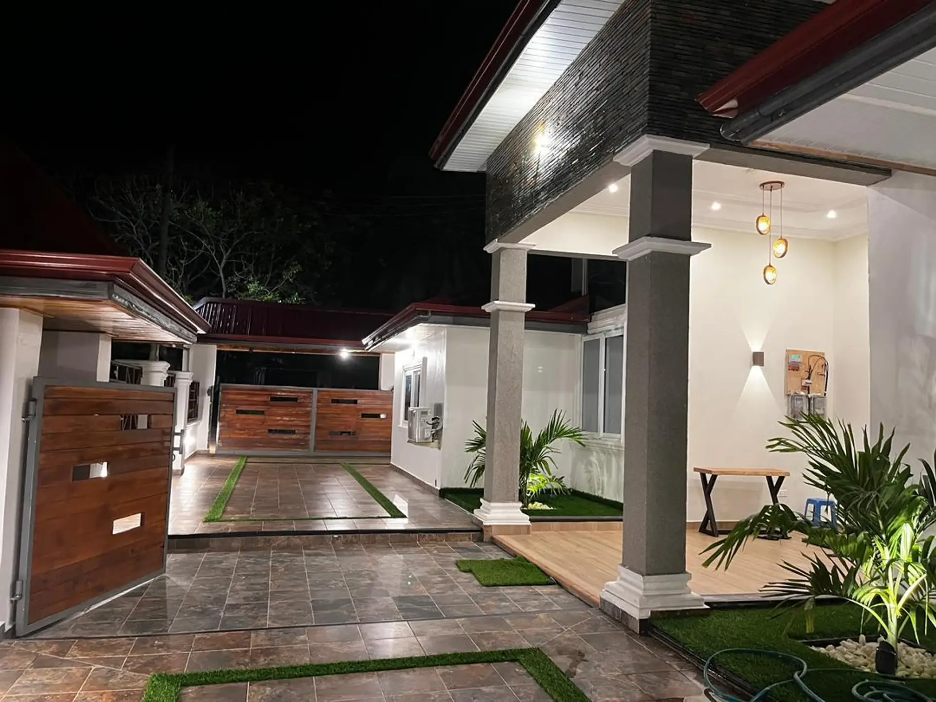 Private tiled courtyard, timber gate and lantern-lit porch at night