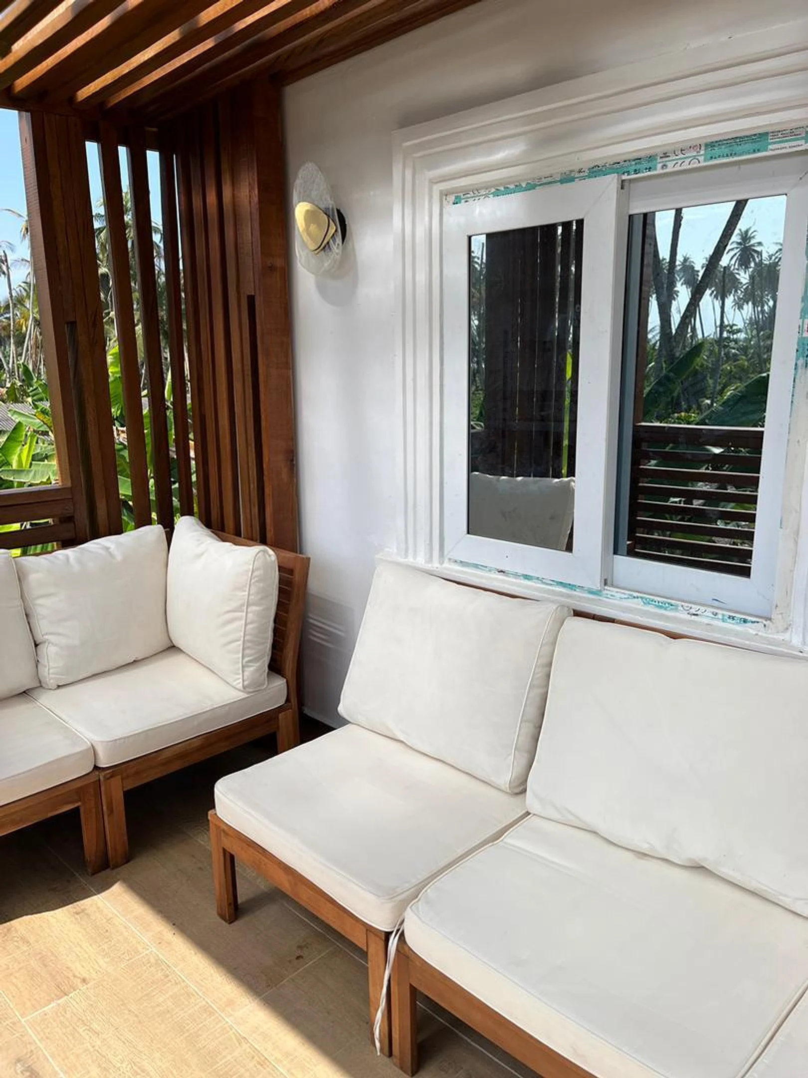 White-cushioned seating on the sunlit upstairs balcony